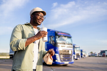 Truck driver going for lunch break eating fast food at truck stop.