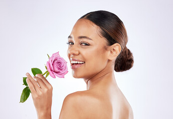 Rose, flower and portrait of happy woman with skincare or healthy dermatology on studio background....
