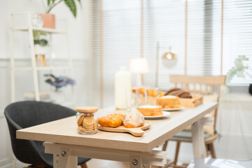 Light streams through a window onto a contemporary dining table with a delicious breakfast spread