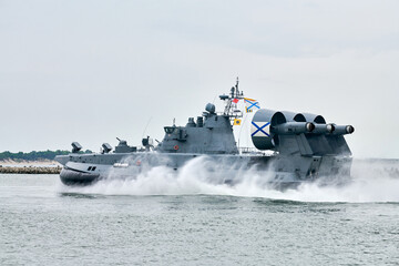 Hovercraft warship armed with armament sails into sea toward military target to attack and destroy enemy, military hovercraft ship performing strategic maneuver, Russian sea power deployment