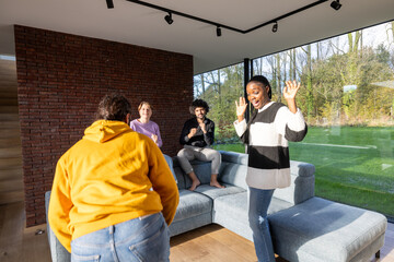 Fototapeta premium A group of individuals is gathered around a sofa in a living room, engaged in conversation or activities like sharing stories or enjoying leisure time