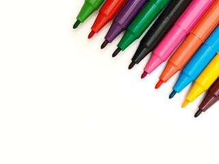 Multi colored markers on white background on top right corner, closeup. Markers for school and college.