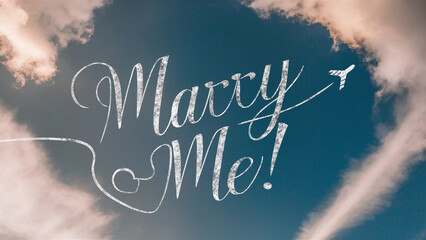 "Marry Me!" message written in airplane trail in the sky, marriage proposal, public love declaration