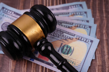 Law and justice concept. A gavel with bank notes under it placed on a wooden table.
