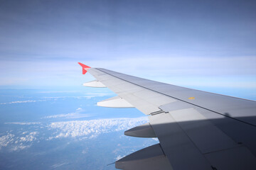 Obraz premium Amazing view from airplane window, Beautiful of Airplane wing with clouds and blue sky on sunset light background