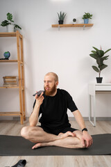 A man is engaging in yoga at his house while having a conversation over the phone