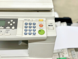 事務所の複合コピー機の操作パネルと用紙