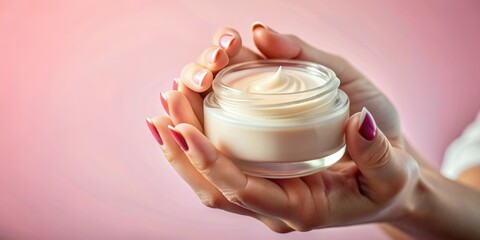 Hands of a beautiful well-groomed woman with a cream jar on a pink textural background. Moisturizer for clean and soft skin in the winter. I love the body. Healthcare concept.