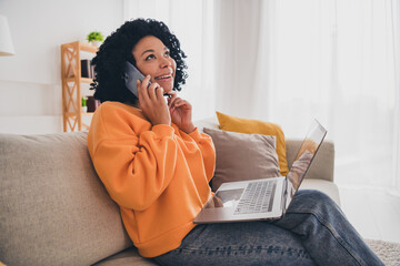 Photo portrait of lovely young lady talk phone work sit sofa dressed casual orange clothes cozy day...