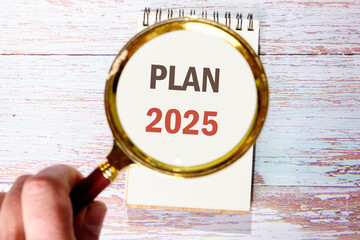 Planning goals and success concept. Text PLAN 2025 the inscription appeared through a magnifying...
