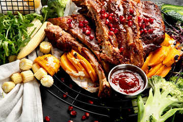Pork ribs with vegetables on black background. Food for picnic concept