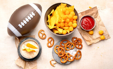 Snacks for watching an American football game. Beer, chips, pretzels, sauce on wooden background