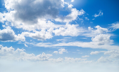 Obraz premium A spring, summer blue sky background with white fluffy clouds in a warm climate.