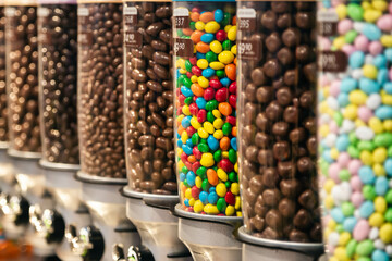 Transparent plastic tubes full of colorful candies, close up..