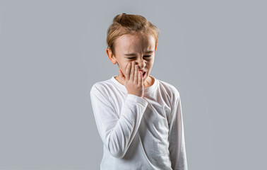 Little child suffer from toothache gray background. Toothache painkiller. Dental disease. Toothache...