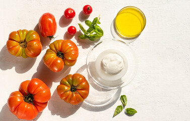  Mozzarella Bufala, Cherry and Ox's Heart tomatoes and basil. Italian Southern Ingredients for summer recipes, Mediterranean diet, farmers  healthy food. White background, sunlight, summer vibes