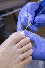 Young woman getting Pedicure with milling cutter in beauty salon, closeup