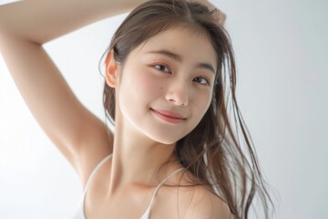 Young Asian woman with smooth underarms on white background.  