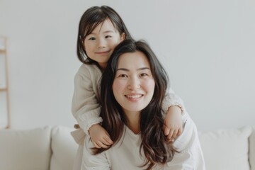 Mother holding her daughter in her arms smiling at the camera.