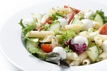 Pasta salad with vegetables and mozzarella cheese isolated on white background. Close up