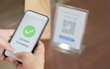 Closeup hands hold smartphone to transfer money by electronic transaction from mobile app.