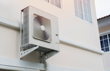 Heat pump or large air conditioning placed on wall of modern house.