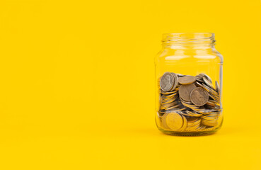 Saving coins in a glass jar, accumulating balance, creating financial discipline. income from work...
