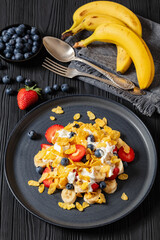 fresh berries, banana with corn flakes and yogurt