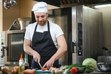 Chef cook in uniform cooking in the big cooker at the restaurant kitchen