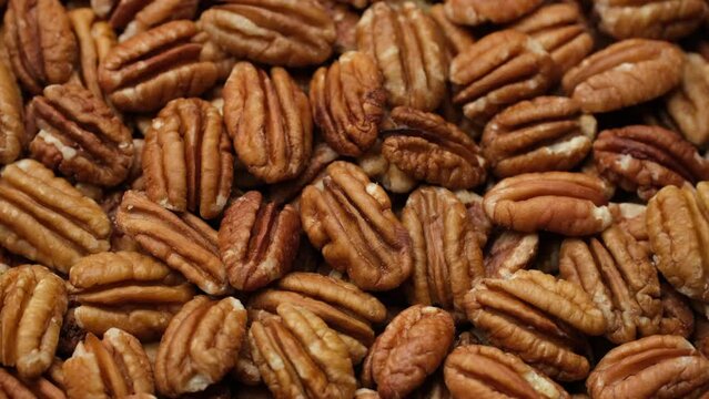 Zoom frame heap of pecan nuts close up, rotation. Healthy food concept