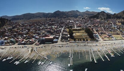 Copacabana Town on the edge of Lake Titicaca with boats on the edge of the lake and mountains...