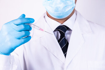 Doctor in blue gloves holds a medical syringe for injection
