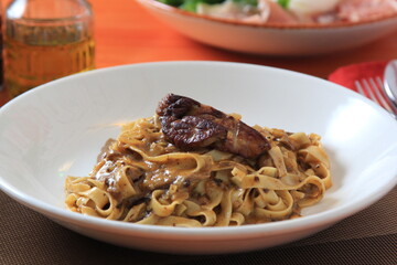Grilled Foie gras steak with with Fettuccine pasta on restaurant table
