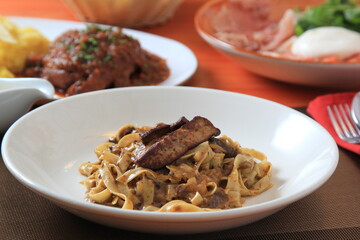 Grilled Foie gras steak with with Fettuccine pasta on restaurant table