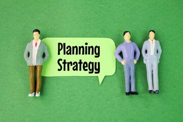 miniature people and colored paper with the word planning strategy. business strategy concept