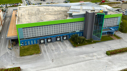 Aerial view of a building for industrial use. There are offices and a large car park.