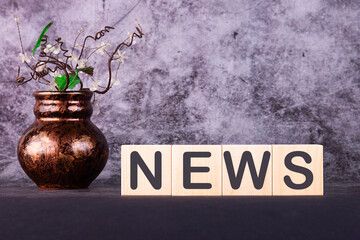 Wooden news sign on cubes on a grey background