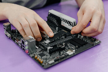 system administrator installing SSD into motherboard, assembling PC of different accessories or...