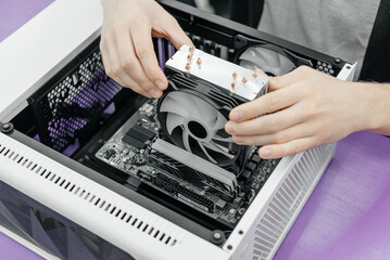 system administrator installing motherboard into system unit, assembling PC of different accessories or components, close-up view of hands, computer repair and maintenance concept
