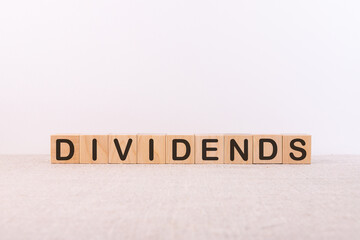DIVIDENDS word made with building blocks on a light background
