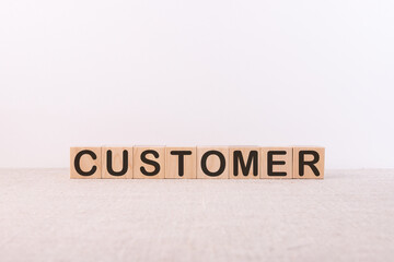 Customer word concept written on wooden cubes on a light table and a light background
