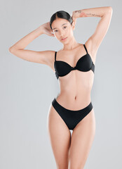 Fototapeta premium Body, fitness and portrait of woman in underwear on studio gray background for health or wellness. Aesthetic, cosmetics and natural with confident or serious model in lingerie for feminine skincare