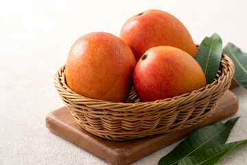 Fresh slice cut juicy mango on gray table background with leaf.