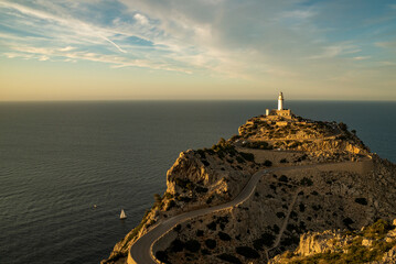 Sailboat sailing around Cap de Formentor lighthouse at sunset, Majorca Island, Balearic Islands,...