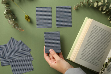 A tarologist makes a spread, on a dark background.