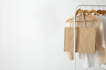 A bag hangs on a hanger with clothes