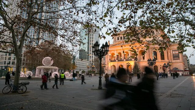 Zeitraffer: Alte Oper Frankfurt in der D&auml;mmerung mit weihnachtlicher Beleuchtung und Passanten