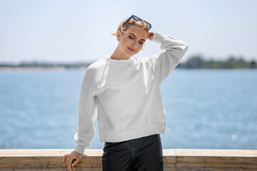 Mockup of a white sweatshirt on a girl with glasses, on the background of the river, clothes with...