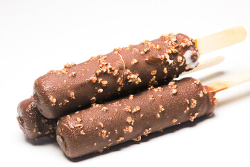 ice cream sticks covered in chocolate and nuts isolated on a white background