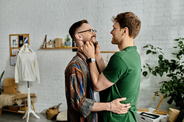 Two men stand together in a designer workshop, hugging and looking at each others eyes